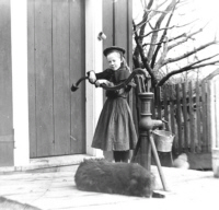 Girl at pump with faithful doggie - c1895